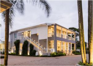 a large white building with palm trees in front of it at Luxe Avondale Boutique Hotel in Durban