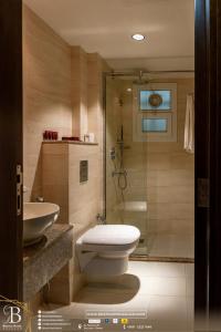 a bathroom with a toilet and a shower and a sink at Bristol Hotel Salalah in Salalah