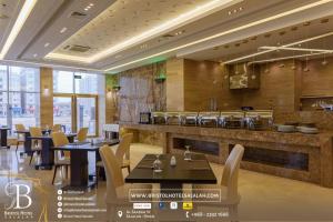 a restaurant with tables and chairs and a bar at Bristol Hotel Salalah in Salalah