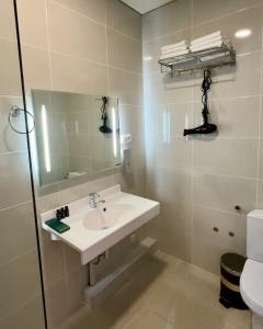 a bathroom with a sink and a mirror and a toilet at SK Hotel in Bishkek