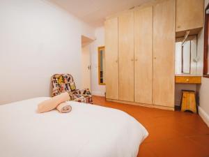 a bedroom with a white bed and a chair at Beachfront property, Victoria Bay, Garden route in Victoria Bay