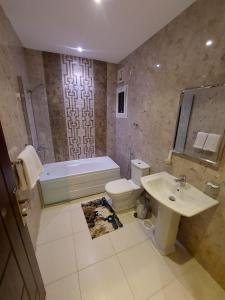 a bathroom with a sink and a toilet and a bath tub at Orvana Al Naseem Hotel in Makkah