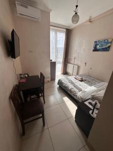 een slaapkamer met een bed en een bureau met een stoel bij Glori in Tbilisi City