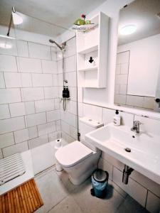 a white bathroom with a toilet and a sink at Casa Gala in Corralejo
