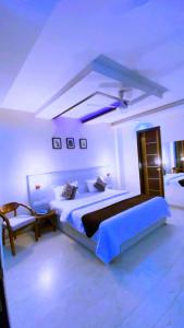 a bedroom with a large bed and a chair at Cassava Stay close to Visa Center in New Delhi