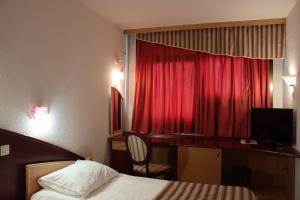 a hotel room with a bed and a red curtain at MC Hotel in Žalec