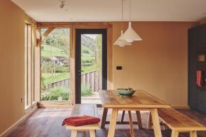a dining room with a table and benches and a window at Hay Barn in Trefeglwys