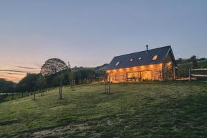 a large wooden house on a grassy field at Hay Barn in Trefeglwys