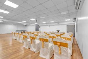 a room with rows of chairs with white and orange bows at UPAR Hotels Indiranagar in Bengaluru