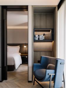 a hotel room with a bed and a blue chair at Shanghai Shang Ying CHAO Hotel in Shanghai