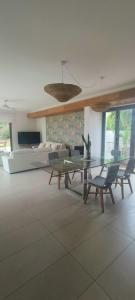 a living room with a table and chairs and a couch at Villa golf de Montchoisy in Mont Choisy