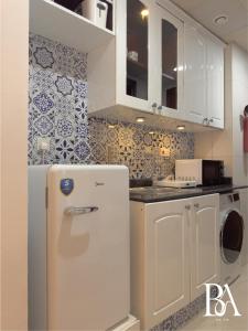 uma cozinha com uma geladeira branca em um cômodo em Bel Air -- Sea View Studio em Ras al-Khaimah