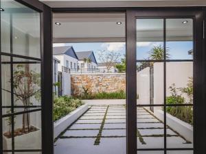 una puerta abierta a un jardín con vistas a una casa en Moorlands Manor, en George