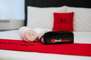 Una toalla blanca y una bolsa sobre una cama. en Reddoorz at Kanaka Guest House Bengkulu, en Bengkulu