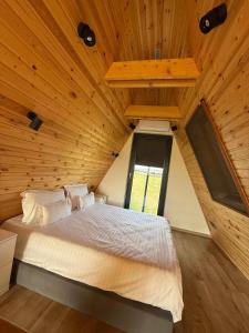 1 dormitorio con cama grande en el techo de madera en Vatra Barsei, en Tohanu Nou