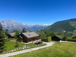 una casa en una colina con montañas al fondo en Spacieux appartment 4 Vallées La Tzoumaz Verbier, en Riddes