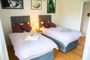 two beds sitting next to each other in a room at Y Beudy at Coed Melin Aberporth in Tremain