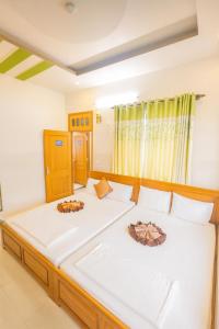 a bedroom with two beds with white sheets at Hưng Phát Hotel Phú Yên in Phu Yen