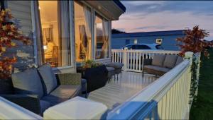 un porche con sofás y sillas en una casa en Lovely 8 Berth Caravan With Large Decking At Withernsea Sands Ref 79005Kg, en Waxholme