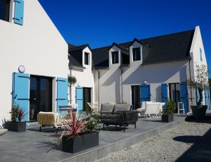 a patio with couches and chairs in front of a house at Loc' Maria - Groix Locations in Groix