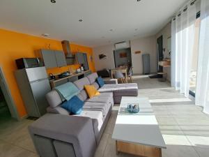 a living room with a couch and a table at Havre de paix en Drôme villa moderne climatisée - jacuzzi "la maison d'à côté" in Chatuzange-le-Goubet