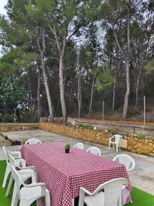 a table with a red and white tablecloth and white chairs at Buenas vistas y privacidad, tranquila y fresca villa en el bosque de Valencia con una magnífica piscina de 80m2 in Lliria