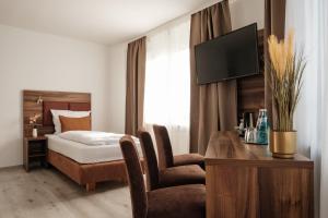 a hotel room with a bed and a desk with a television at sQuare Hotel in Frankfurt/Main