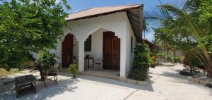 a small house with a porch and a table at Nionje Garden Villa in Jambiani
