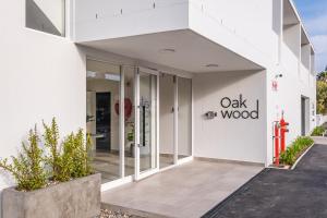 a white building with the oak wood sign on it at The Wild Oak in Hermanus