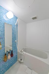 a bathroom with a bath tub and a mirror at 沖縄SunSea海景酒店整套公寓 那霸机场20分钟车程  +32 photos