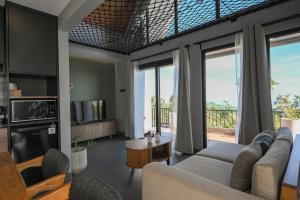 una sala de estar con un sofá y una mesa en Le Nid du Clair de Lune, en Gitgit