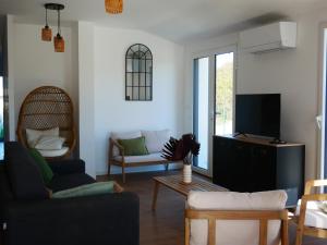 a living room with a couch and a tv at Loc' Maria - Groix Locations in Groix