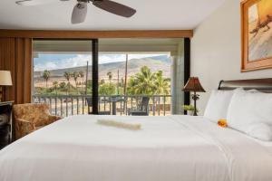 a bedroom with a large white bed and a balcony at Lahaina Shores 234 in Wainee +42 photos