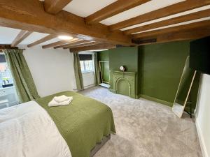 a green bedroom with a bed and a fireplace at Old Grey Mare in York