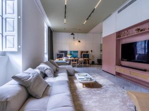 een woonkamer met een grote bank en een tv bij Manila Home in Manilla