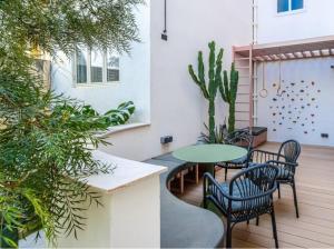 een terras met een tafel, stoelen en planten bij Manila Home in Manilla