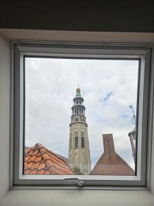 a view of a clock tower from a window at Number 9 holiday apartments in Middelburg