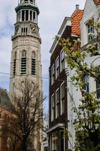 a tall tower with a clock on top of a building at Number 9 holiday apartments in Middelburg