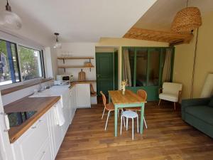 a kitchen and dining room with a table and chairs at Douce Parenthèse au bord de l'eau in La Celle-sous-Gouzon