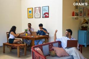 a group of people sitting at a table with laptops at Gram's at Shivom, Pawna Lake in Lonavala