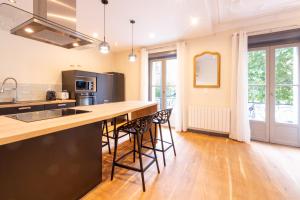 a kitchen with a large island with bar stools at Séjour tout confort Emplacement exceptionnel in Rennes
