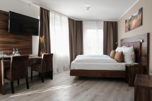 a bedroom with a bed and a desk with a computer at The sQuare Hotel in Frankfurt/Main +49 photos
