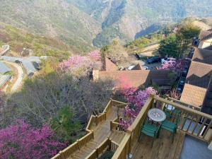 - un balcon avec des escaliers, une table et des fleurs dans l'établissement Spring Ground Resort, à Renai