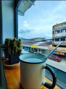 een kopje koffie op een vensterbank met uitzicht op een stad bij Sunny Nest in Gopeng +29 foto's
