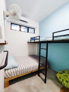 a room with two bunk beds and a fan at Sunny Nest in Gopeng