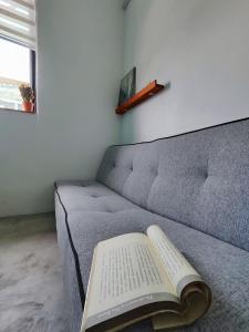 een boek ligt op een bank met een boek bij Sunny Nest in Gopeng