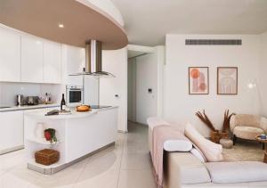 Il comprend un salon blanc avec un canapé et une cuisine. dans l'établissement Suite 1003 at Althea Residence, à Scala
