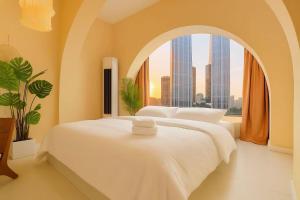 a bedroom with a large white bed with a window at Chongqing City Center River View B&B in Chongqing