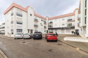 a parking lot with cars parked in front of a building at Coast 2 Bedroom Apart Setúbal 45 min from Lisbon in Setúbal
