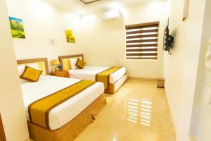 a bedroom with two beds and a window at Minh Cường Hotel Mộc Châu in Mộc Châu